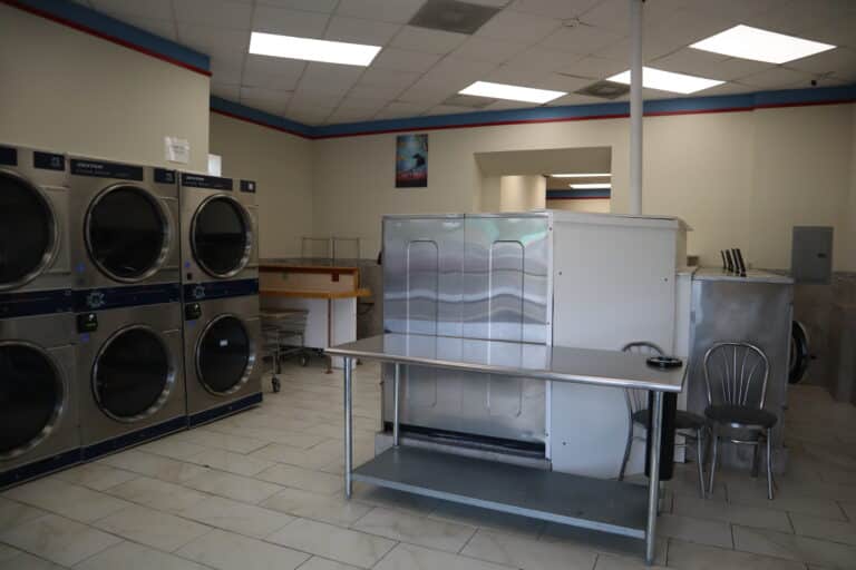 a laundry room with a table and dryers